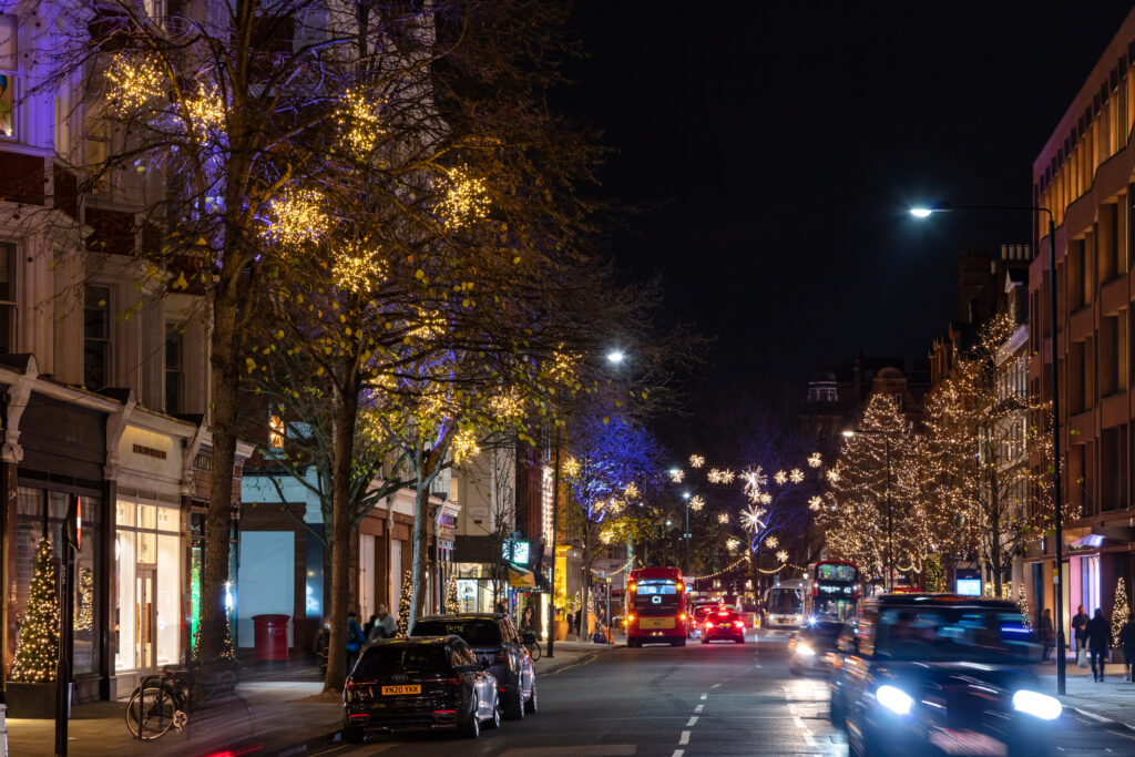 outdoor christmas lighting in London. wrapped trees across street light motifs